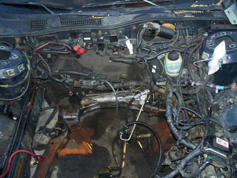 1992 Ford Taurus - The engine bay is mostly empty, revealing the car's internal structure and wiring harnesses.