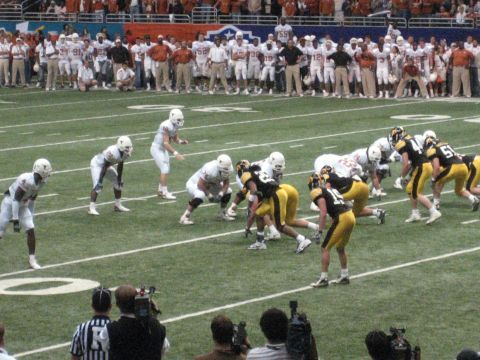 1986 Ford Bronco - A football game is underway with players from two teams lined up on the field.