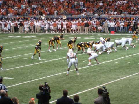 1986 Ford Bronco - A football game is underway with players on the field and a crowd in the stands.