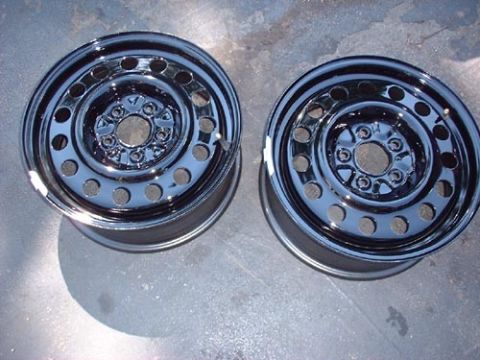 1997 Ford Crown Victoria - Two chrome steel wheels are shown on a concrete surface.