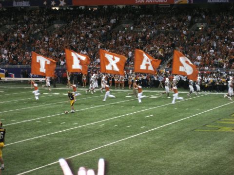 1986 Ford Bronco - A football game scene with large orange flags spelling TEXAS and players on the field.