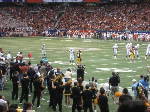1986 Ford Bronco - A football game is underway with players on the field and spectators filling the stadium seats.