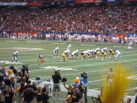 1986 Ford Bronco - A football game is underway with players on the field and a packed stadium of fans.
