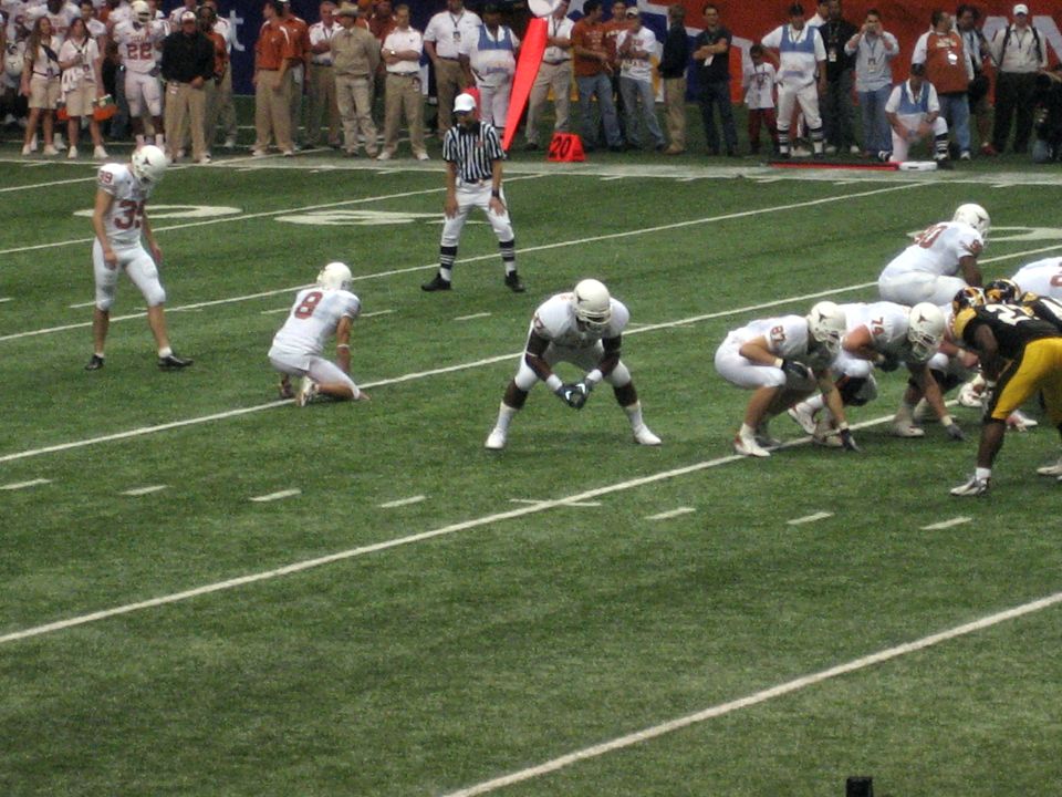 Football players lined up on a green field during a game