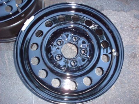1997 Ford Crown Victoria - A close-up view of a black steel wheel, with another wheel visible in the background.