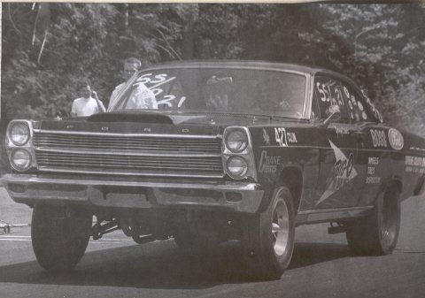 1967 Ford Fairlane - 1967 Ford Fairlane drag car with racing decals and hood scoop at a drag strip.