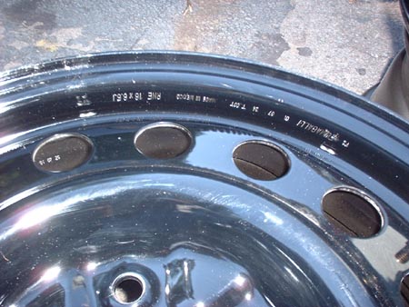 1997 Ford Crown Victoria - Close-up of a steel wheel showing manufacturing markings and size information.