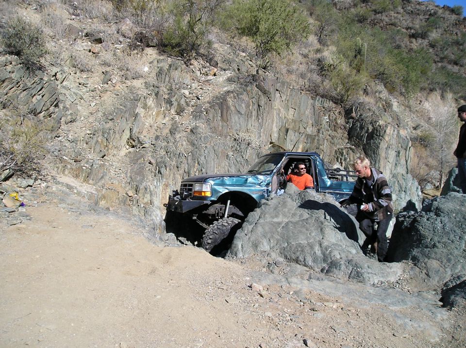 Teal 1995 Ford F-150 off-roading on rocky terrain
