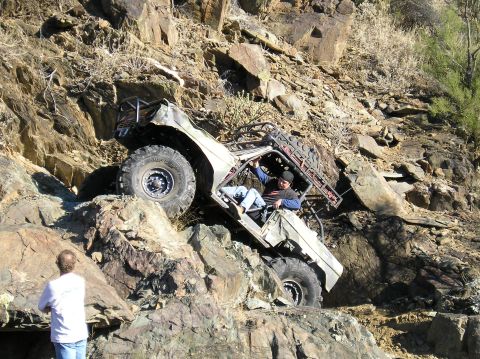 1993 Ford Bronco - Vehicle attempting to climb a difficult rocky incline with a person watching.