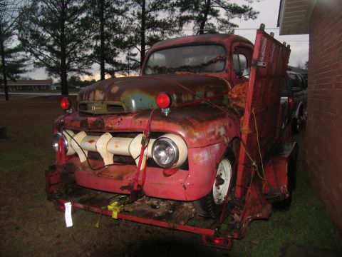 1952 Ford Pickup - This heavily rusted pickup truck, likely a 1951 model, is secured to a trailer for transport.