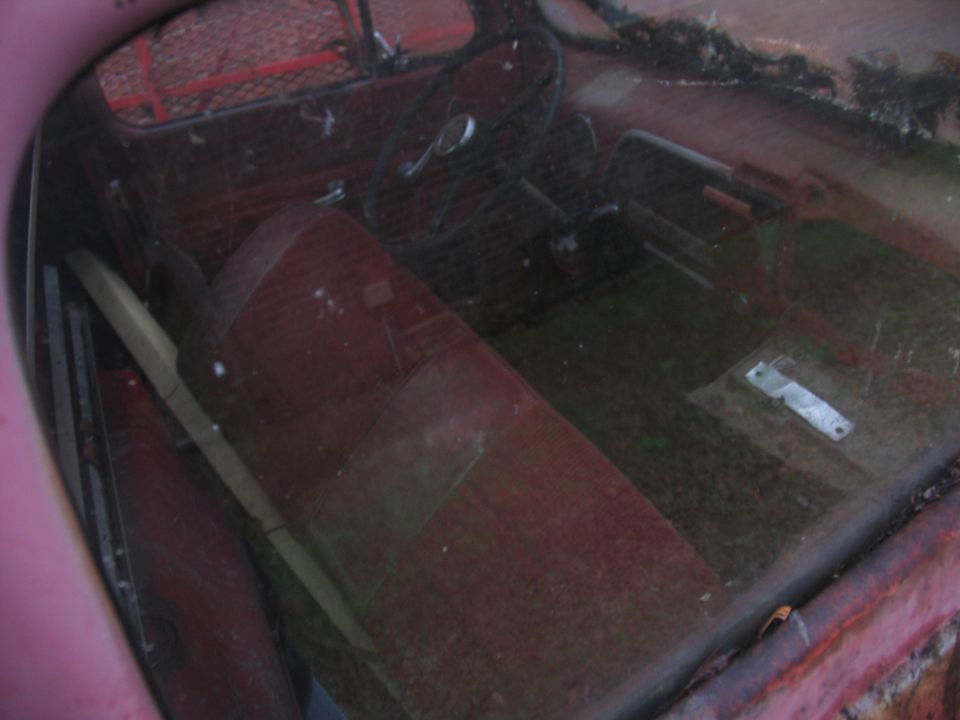 1952 Ford Pickup interior showing red bench seat, steering wheel, and dashboard