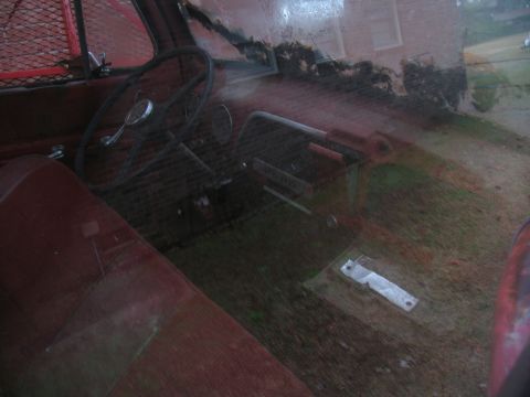 1952 Ford Pickup - The interior of an old truck shows signs of wear and tear, with a dusty dashboard and floor.