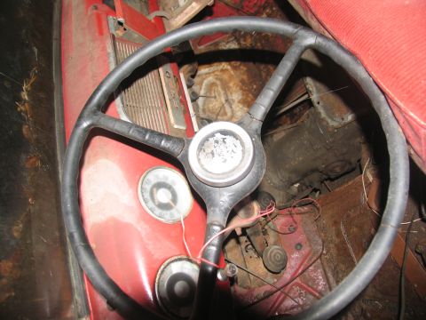 1952 Ford Pickup - The interior of a vintage truck shows a steering wheel, dashboard, and exposed mechanical components.