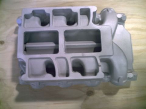 1969 Ford Fairlane - This is an aluminum intake manifold, likely for a V8 engine, shown on a wooden surface.