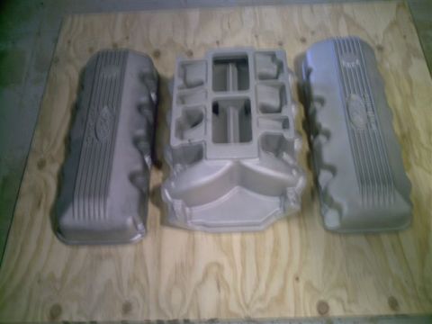1969 Ford Fairlane - Two Ford valve covers flank a Ford intake manifold, all resting on a plywood surface.