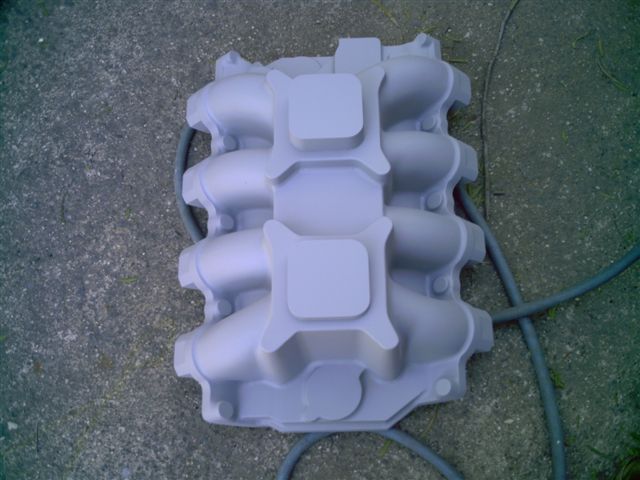 Media-blasted aluminum dual-quad V8 intake manifold on concrete driveway
