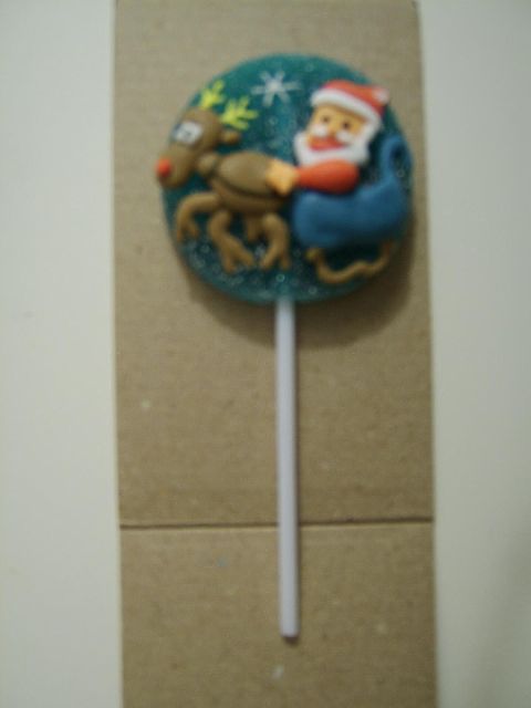 1989 Ford Bronco - A festive lollipop decorated with Santa Claus and a reindeer, presented on a stick.