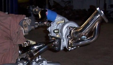 1988 Pontiac Fiero - a stockish aftermarket downpipe going the wrong way for this application.