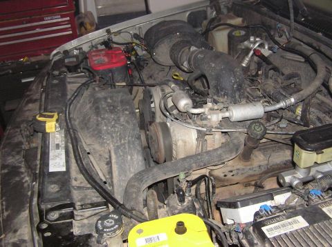 2000 Chevrolet Tahoe - The engine bay of a vehicle, showing various components like the battery, hoses, and air intake system.
