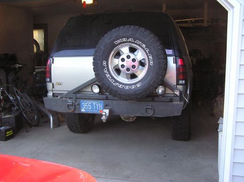 2000 Chevrolet Tahoe - The rear of a silver 2000 Chevrolet Tahoe is visible, equipped with a spare tire and a custom bumper.