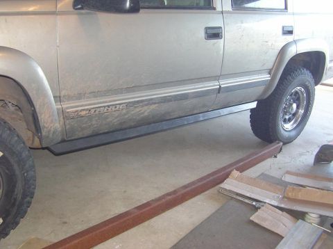 2000 Chevrolet Tahoe - A silver Chevrolet Tahoe is shown from the side, with its running boards and tires visible.