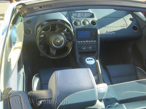 1985 Ford Mustang - The interior of a luxury sports car features a navigation screen and a gated shifter.