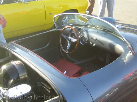 1985 Ford Mustang - Interior view of a gray convertible with a wood-rimmed steering wheel and red seats, parked next to a yellow car.