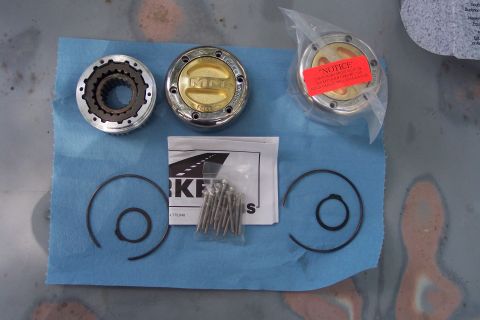 1996 Ford Bronco - Set of manual locking hubs, including one in packaging with a red "Notice" sticker, along with retaining rings and screws.
