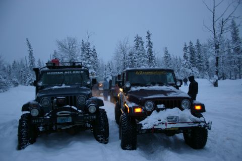 2003 Jeep TJ - Two Jeep TJs parked in a snowy forest during winter, with trees covered in snow.