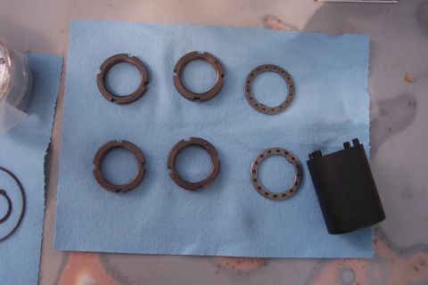 1996 Ford Bronco - Hub lock rings and a cap laid out on a shop towel, possibly for a vehicle repair or upgrade.