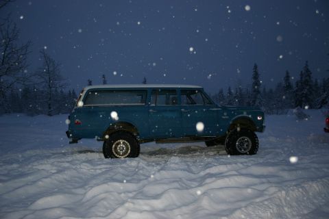 2003 Jeep TJ - A blue station wagon with a white roof sits in a snowy landscape during a snowfall.