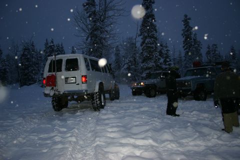 2003 Jeep TJ - Group of SUVs parked in a snowy forest during a snowfall.