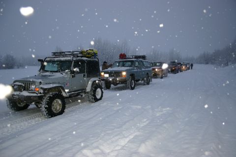 2003 Jeep TJ - A convoy of Jeeps and SUVs navigate a snow-covered road during a winter outing.