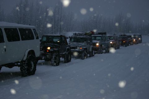 2003 Jeep TJ - Multiple off-road vehicles travel in a convoy through a snow-covered area.