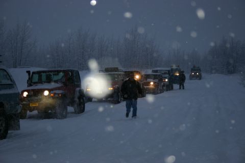 2003 Jeep TJ - A convoy of Jeep TJs navigates a snowy road during a winter storm.