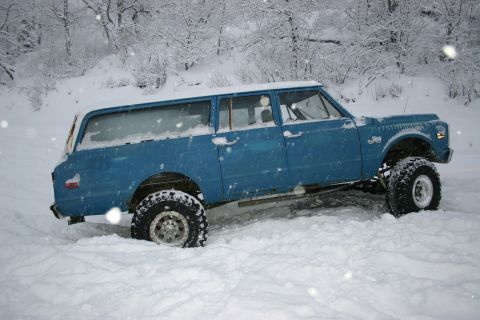 2003 Jeep TJ - Lifted K5 Blazer partially buried in snow during winter conditions.