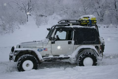 2003 Jeep TJ - A white Jeep Wrangler TJ is partially submerged in snow, with "Rubicon" badging visible on the hood.