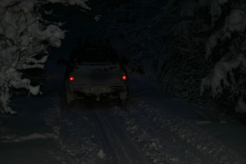 2003 Jeep TJ - A 2003 Jeep TJ drives on a snowy track at night.