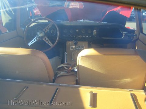 1985 Ford Mustang - Interior view of a classic car's dashboard and tan leather seats, with the hood open.