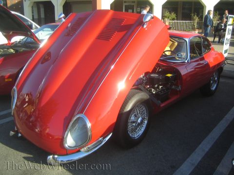 1985 Ford Mustang - A red classic sports car is displayed with its hood open, revealing the engine compartment.