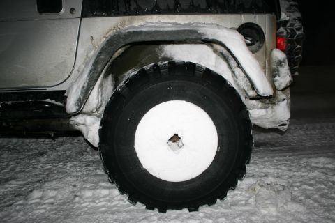 2003 Jeep TJ - A silver Jeep Wrangler sits in the snow, its rear tire and spare tire visible.