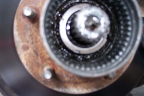 1996 Ford Bronco - A close-up view of a manual hub assembly, showing its internal splines and rusty mounting bolts.