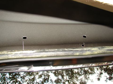 1996 Ford Bronco - Close-up of the interior headliner showing two holes drilled for a grab handle installation.