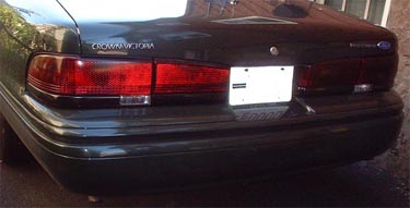 1997 Ford Crown Victoria - The rear of a dark green 1997 Ford Crown Victoria is shown, its taillights and trunk.