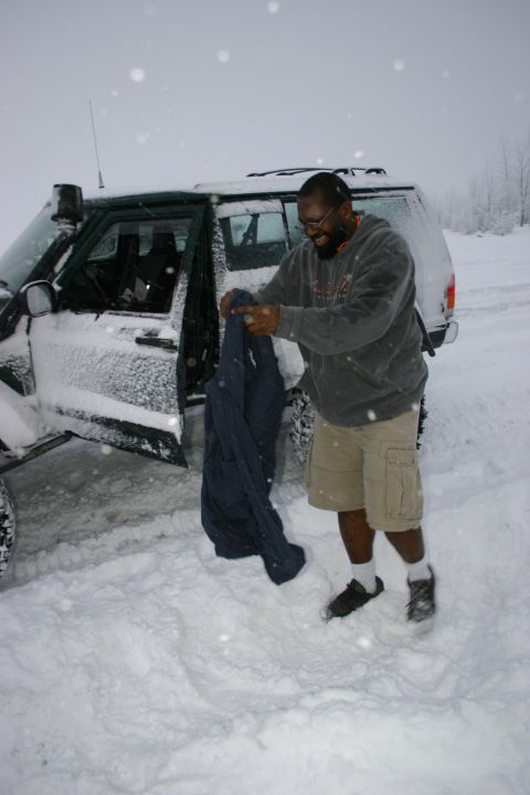 2003 Jeep TJ - A man stands next to a green 2003 Jeep Wrangler in a snowy environment.