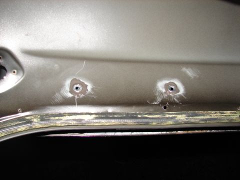 1996 Ford Bronco - This photo shows the interior of a vehicle door panel with two holes drilled into it.