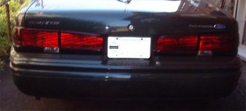 1997 Ford Crown Victoria - Rear view of a dark green 1995 Ford Crown Victoria, showing its distinctive taillights and license plate area.
