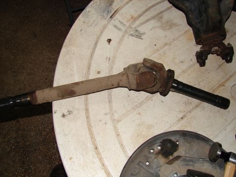 1996 Ford Bronco - A rusty driveshaft and differential are laid out on a table, suggesting a repair or parts inventory.