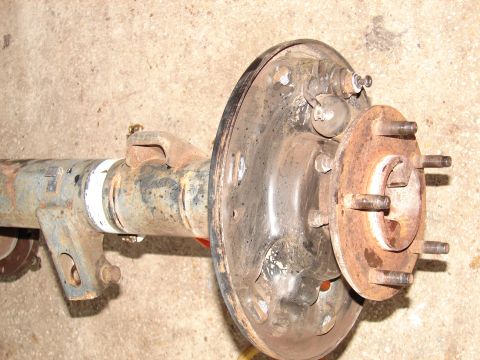 1996 Ford Bronco - Close-up of a vehicle's rear axle assembly, showing the brake drum and hub with wheel studs.