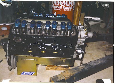 1992 Ford Mustang - Engine block with blue valve covers and Canton oil pan sits on a shop floor.